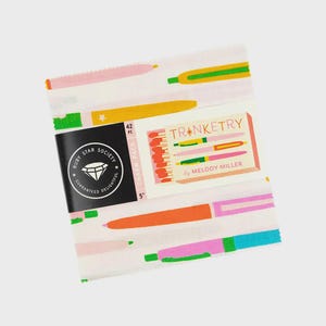 May include: A white fabric charm pack with a colorful pen pattern. The pack is wrapped with a black label that reads "Ruby Star Society" and "Guaranteed Delightful." A smaller label reads "Trinketry by Melody Miller" and "42 PC Charm Pack 5 inches."