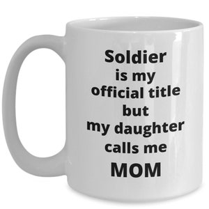May include: White ceramic coffee mug with a black text design that reads "Soldier is my official title but my daughter calls me MOM".