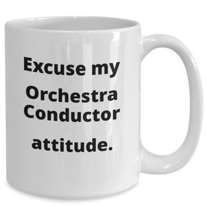 Könnte beinhalten: Eine weiße Keramik-Kaffeetasse mit schwarzem Text, der "Excuse my Orchestra Conductor attitude." lautet.