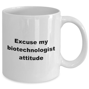 Puede incluir: Taza de café de cerámica blanca con texto negro que dice "Excuse my biotechnologist attitude".