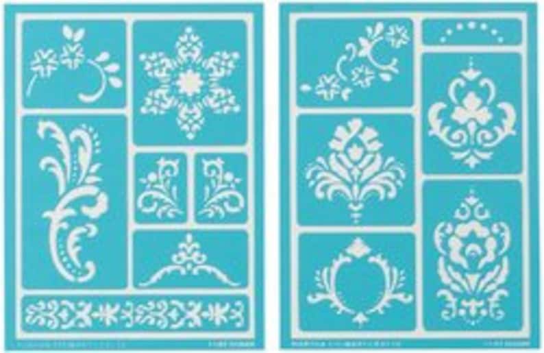 May include: Two blue plastic stencils with white designs. The stencils feature various floral and damask patterns, including a snowflake, a large floral motif, and a border.