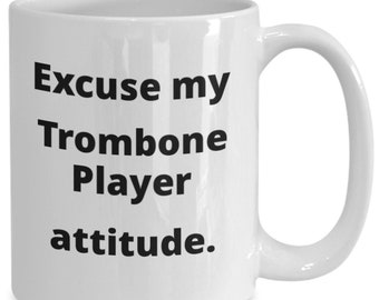 May include: White ceramic coffee mug with black text that reads "Excuse my Trombone Player attitude."
