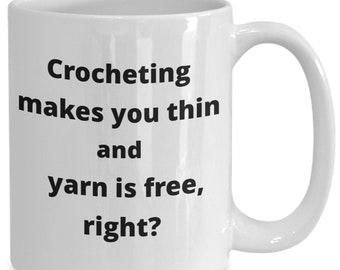 May include: White ceramic coffee mug with black text that reads "Crocheting makes you thin and yarn is free, right?"
