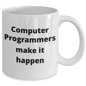 Op de afbeelding: Witte keramische koffiemok met zwarte tekst die "Computer Programmers make it happen" luidt.