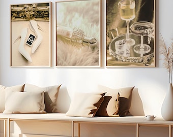 May include: Three framed art prints with a glamorous theme. One print features white high heels and a small card. Another shows a perfume bottle on faux fur. The third print displays a cocktail glass and a decorative tray.