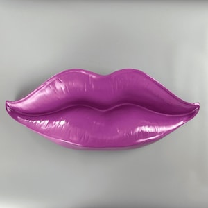 May include: A large, bright purple, glossy, plastic sculpture of a pair of lips.