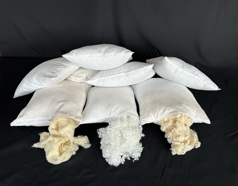 May include: Six white pillowcases with zippers are open to reveal the filling inside. Three pillowcases are filled with white polyester fiberfill, and three pillowcases are filled with white down feathers.