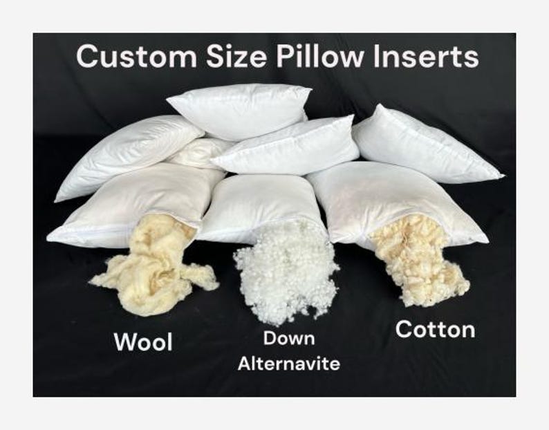 May include: A close-up of three white pillow inserts with different fillings: wool, down alternative, and cotton. The pillow inserts are arranged in a row with the filling visible.
