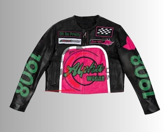 Op de afbeelding: Zwart leren jack met een cropped design, met roze en groene graphics. De jas heeft de tekst "Alpha Woman" en "8008" op de mouwen. Patches met "Oh So Pretty" en een geblokte vlag.