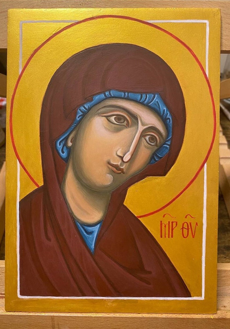 May include: A religious icon painting of the Virgin Mary with a blue head covering and a maroon robe. The background is gold with a red halo around her head. The text "MP OY" is written in the bottom right corner.