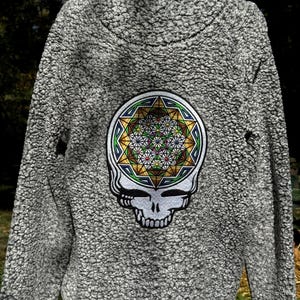 May include: Gray fleece jacket with a colorful geometric design and a skull graphic on the back.