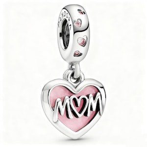 May include: A silver charm with the word "MOM" in a heart-shaped pendant. The heart is filled with pink enamel and surrounded by a silver border. The charm has a silver loop with the brand name and small pink heart-shaped accents.