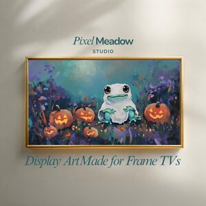 Puede incluir: Una pantalla de arte digital para televisor tipo marco con una pintura de una pequeña rana verde con un disfraz de fantasma blanco, rodeada de calabazas naranjas brillantes en un campo oscuro. El texto dice Pixel Meadow STUDIO.