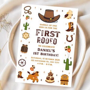 May include: A white invitation with a brown cowboy hat, a cactus, a horseshoe, and a star. The text reads "Saddle Up and Join Us for the First Rodeo to Celebrate Daniel's 1st Birthday! Saturday, 15 October 2025, 123 Anywhere St, Any City, 4 P.M. - 8 P.M."