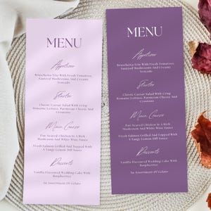 May include: Two elegant menu cards, one lavender and one deep purple, with white text. The menus list appetizers, starters, main courses, and desserts. The menus include dishes like Bruschetta Trio, Caesar Salad, and Vanilla Wedding Cake.