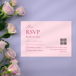 Op de afbeelding: Een roze RSVP-kaart met de tekst "Please RSVP" en een datum. De kaart bevat opties om te accepteren of af te wijzen, een QR-code en een bedankbericht. Roze rozen staan op de achtergrond.