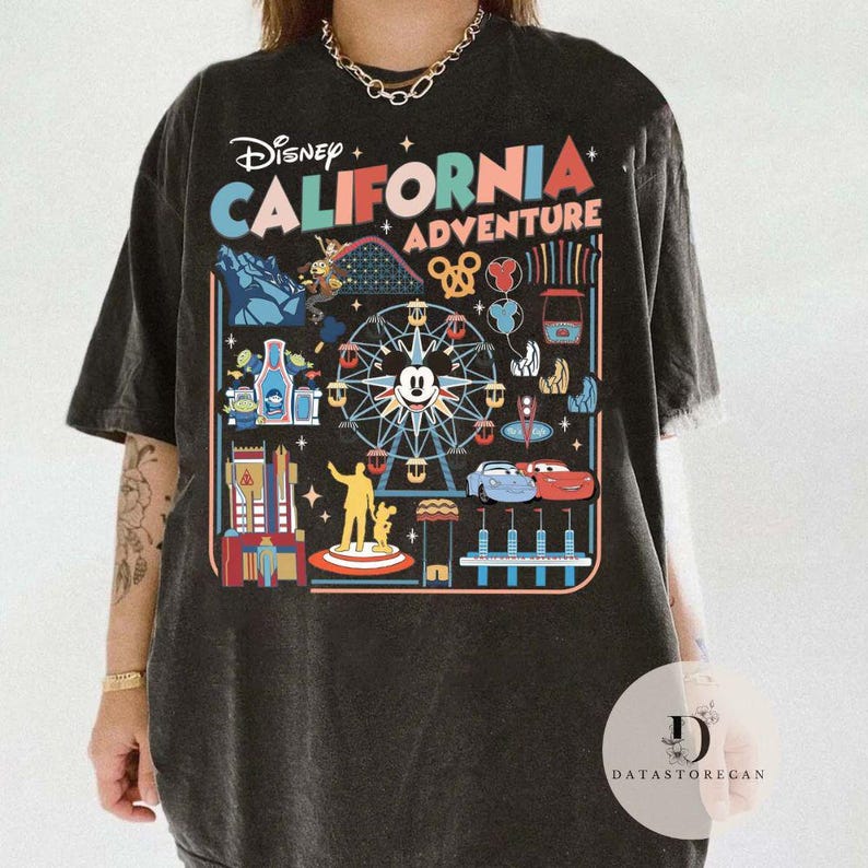 May include: Black t-shirt featuring a colorful graphic of Disney California Adventure. The design includes a Ferris wheel with Mickey Mouse, roller coaster, and other park icons. The text "Disney CALIFORNIA ADVENTURE" is prominently displayed.