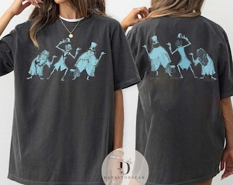 May include: A charcoal gray short-sleeve t-shirt featuring a light blue graphic print of three figures in top hats and formal attire. The front shows the characters facing forward, while the back displays the same three figures from behind.