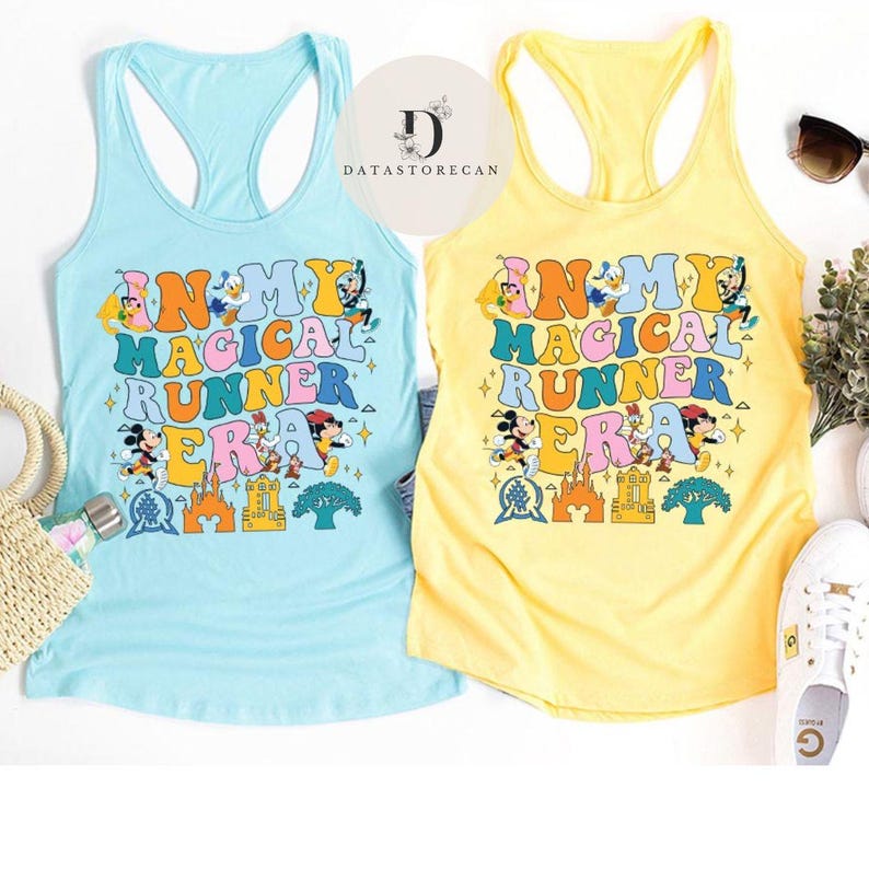 K&ouml;nnte beinhalten: Zwei Tanktops mit hellblauem und gelbem Hintergrund. Die Tanktops zeigen eine bunte Grafik mit dem Text "In My Magical Runner Era" und verschiedenen Disney-Charakteren.