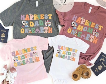 May include: Four t-shirts with a Disney theme. The shirts are in different colors and feature the text "Happiest" with a different word like "Dad", "Mom", "Sister", and "Kid" followed by "One Earth". Each shirt has a different Disney character design.