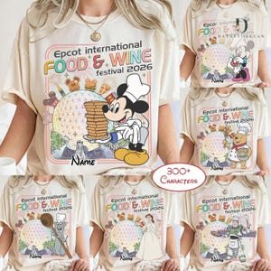 May include: A cream-colored t-shirt featuring a graphic for the Epcot International Food & Wine Festival 2026. The design includes a large geodesic sphere, various food icons, and a Disney character in a chef hat holding a stack of pancakes.
