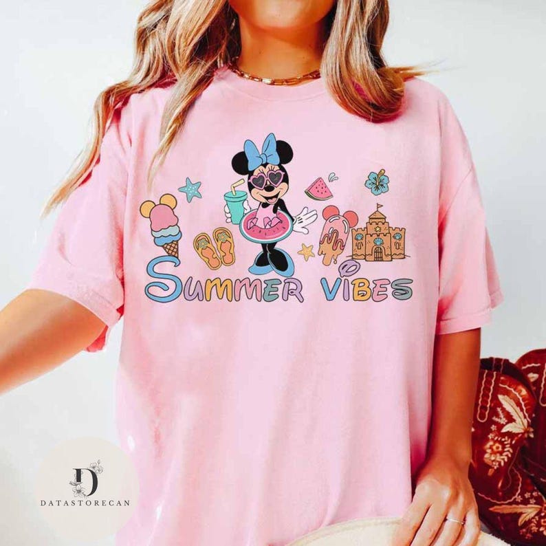 May include: Pink t-shirt with a cartoon image of Minnie Mouse wearing sunglasses and a swimsuit, holding a watermelon and a drink. The text "Summer Vibes" is printed below the image.