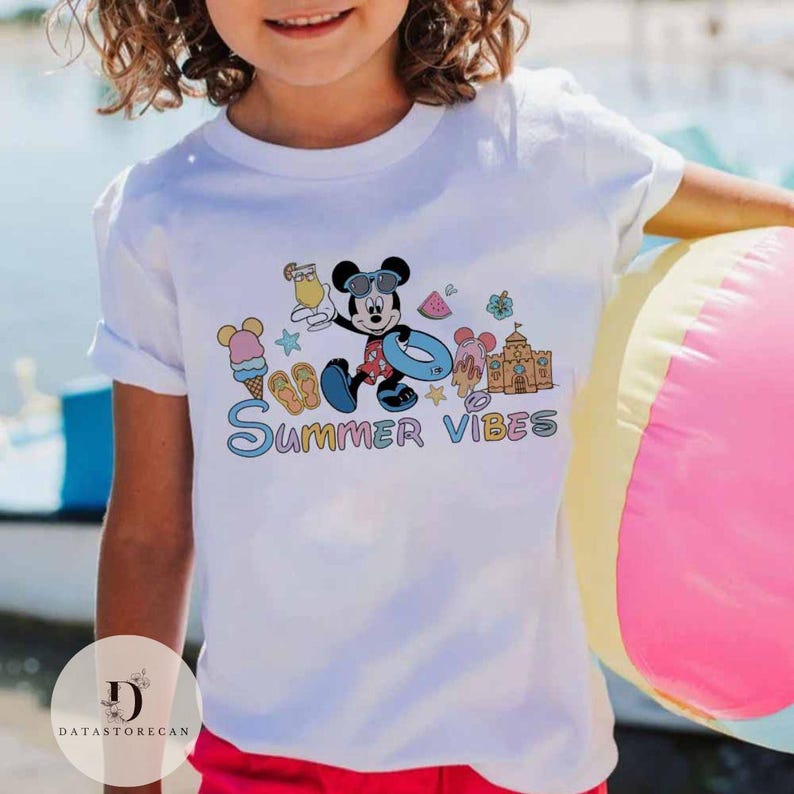 May include: White t-shirt with a colorful graphic of Mickey Mouse on a beach vacation. The graphic includes Mickey Mouse holding a drink, wearing sunglasses and a swimsuit, and a beach umbrella. The text "Summer Vibes" is written below the graphic.