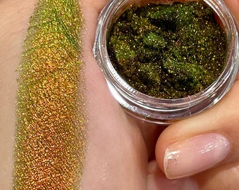 May include: A small jar of green and gold iridescent glitter. The glitter is loose and has a shimmery finish.