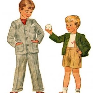May include: Two boys wearing different outfits. One boy is wearing a gray suit with a white button-down shirt and a red tie. The other boy is wearing a green jacket with a white shirt and beige shorts. The boy in the suit is holding a white ball.