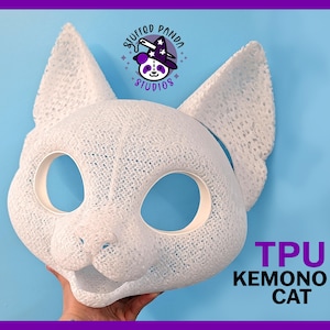 May include: A white TPU Kemono cat mask with large ears and eye openings. The mask is held against a light blue background. The text "TPU KEMONO CAT" is displayed in purple and black.