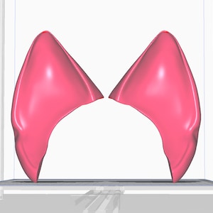 以下が含まれることがあります： 滑らかで丸みを帯びた表面を持つ、ピンク色の猫の耳の3Dプリントモデルです。