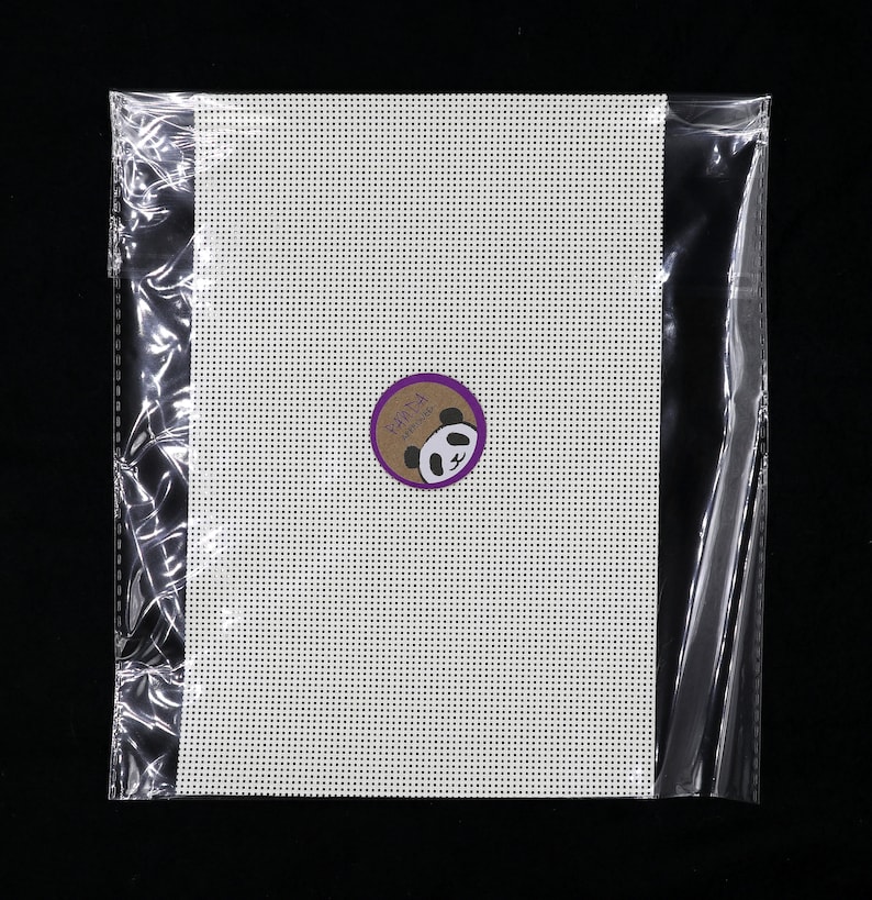 May include: A white plastic canvas sheet in a clear plastic bag. The canvas is for cross-stitch or needlepoint projects. A small round sticker with a panda bear logo is on the canvas.