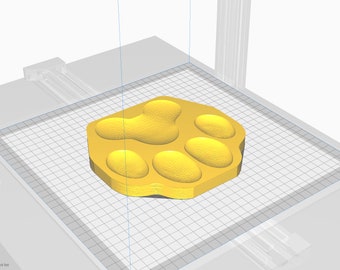 Könnte beinhalten: Ein gelber, 3D-gedruckter Pfotenabdruck mit fünf Zehen. Der Pfotenabdruck befindet sich auf einer weißen Gitteroberfläche.