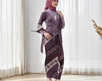 May include: A formal purple outfit, including a long-sleeved top with floral embroidery and a matching patterned skirt. The outfit is paired with a matching head covering and heels. The text "Tron Craft" is visible on the sleeve.