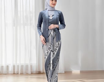 May include: A formal ensemble featuring a gray, long-sleeved jacket, a matching top, and a patterned skirt. The skirt has a diagonal design with floral accents. The outfit is completed with a matching head covering and beige shoes.