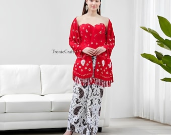 May include: A red, strapless top and matching shawl with white circular patterns. The outfit is paired with wide-leg pants featuring a black and white batik design. The text "TronicCraft" is visible on the left side.