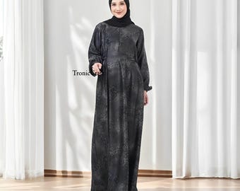 May include: A black maxi dress with a floral pattern. The dress has long sleeves and a high neckline. The model is wearing a black headscarf.