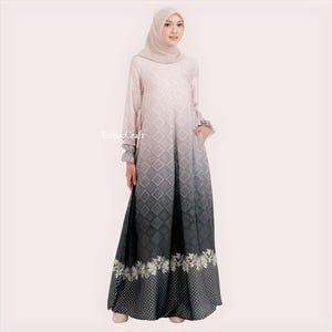 May include: A long, flowing dress with a gradient pattern that transitions from light pink to dark gray. The dress features a geometric pattern and a floral print at the hem. The dress has long sleeves with ruched cuffs.
