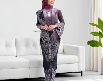 May include: A woman wearing a traditional purple outfit. The outfit includes a long-sleeved top, a patterned skirt, and a matching head covering. A patterned shawl is draped over the shoulders. The outfit is a formal style. The text "TronicCraft" is visible.