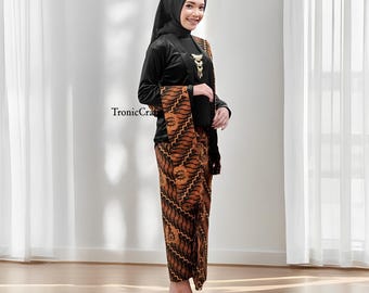 May include: A woman wearing a black long-sleeved top, a patterned brown and black skirt, and a matching shawl. The outfit includes a black head covering and gold-colored sandals. The text "TronicCraft" is visible on the left side.