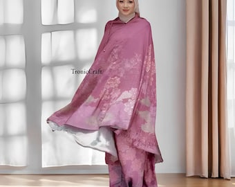 May include: A pink and white patterned prayer shawl with a hood. The shawl has a floral design and a subtle ombre effect.