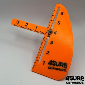 May include: Bright orange ceramic tool with black markings and the text "4SURE CERAMICS." The tool has a curved, fan-like shape with measurements from 1 to 6 inches. A perpendicular arm extends with measurements from 1 to 3 inches.
