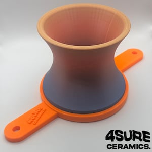 May include: A 3D-printed ceramic piece with a gradient of colors, transitioning from orange to blue. The piece has a unique hourglass shape with an orange handle and the text "4SURE CERAMICS."