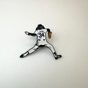Pu&ograve; includere: Spilla smaltata raffigurante un lanciatore di baseball in posa di lancio. La spilla &egrave; bianca, nera e marrone, con il nome "Valenzuela" e il numero "34" sulla maglia. Un oggetto da collezione.