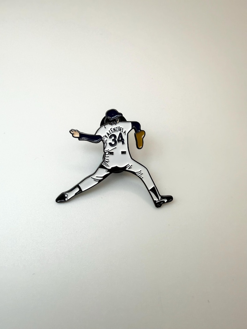 Pu&ograve; includere: Spilla smaltata raffigurante un lanciatore di baseball in posa di lancio. La spilla &egrave; bianca, nera e marrone, con il nome "Valenzuela" e il numero "34" sulla maglia. Un oggetto da collezione.