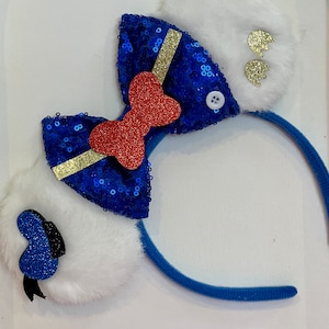 May include: Blue and white sequined bow with a red bow in the center, attached to a blue headband with white fuzzy ears on each side.