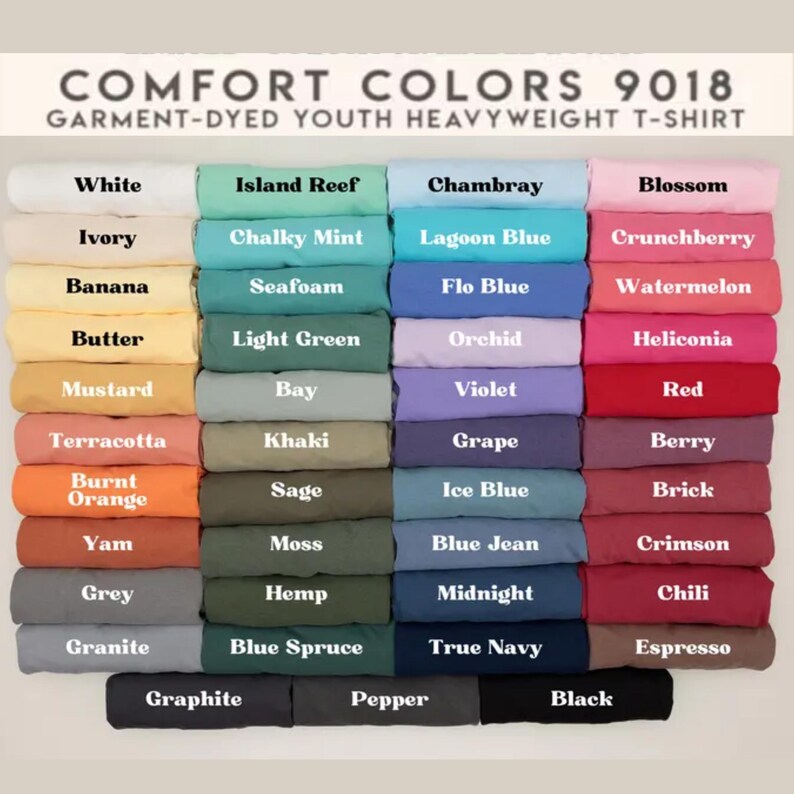 K&ouml;nnte beinhalten: Eine Farbkarte f&uuml;r Comfort Colors 9018 garngef&auml;rbte Youth Heavyweight T-Shirts. Die Karte zeigt eine gro&szlig;e Auswahl an Farben, darunter Wei&szlig;, Elfenbein, Banane, Butter, Senf, Terrakotta, gebranntes Orange, Yam, Grau und Granit. Weitere Farben sind Island Reef, Chambray, Blossom und Schwarz.