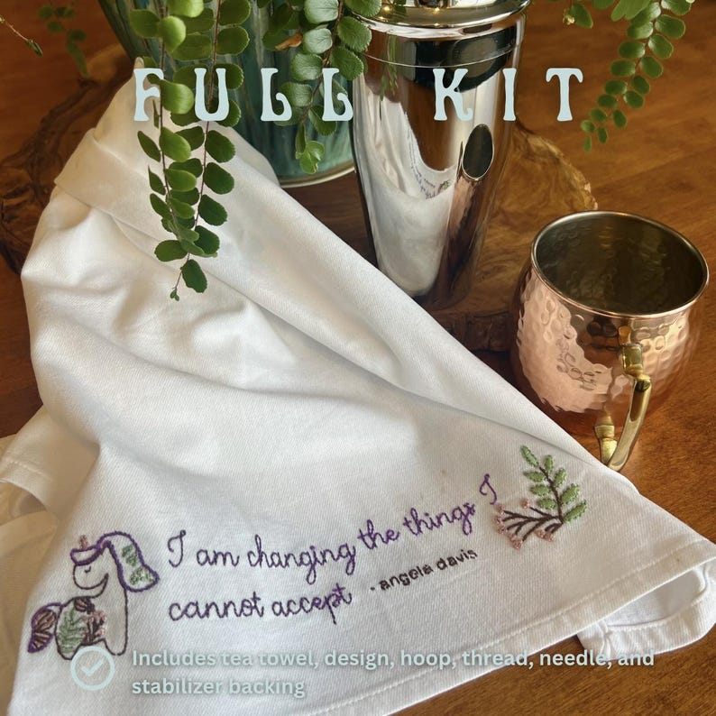 May include: A white tea towel with an embroidered unicorn and the quote "I am changing the things I cannot accept - Angela Davis." The kit includes a cocktail shaker, copper mug, and other supplies.