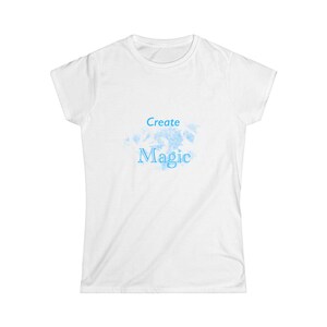 Könnte beinhalten: Weißes T-Shirt mit einem blauen Aquarell-Design und dem Text "Create Magic" in Blau.
