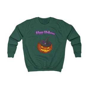 Könnte beinhalten: Ein dunkelgrünes Sweatshirt mit einem Halloween-Motiv. Das Design zeigt einen Kürbis mit Hexenhut und den Worten "Happy Halloween" in lila Schrift darüber. Der Kürbis hat ein geschnitztes Gesicht mit gelbem Leuchten.